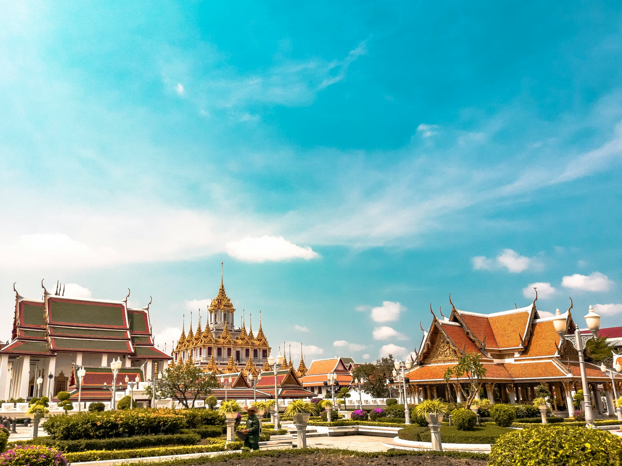 Temple spires under a wide blue sky in Bangkok, Thailand